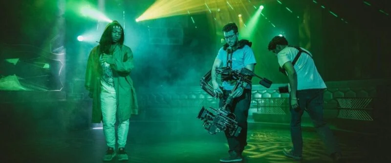 NYC video editor filming in a vibrant studio with dynamic lighting.