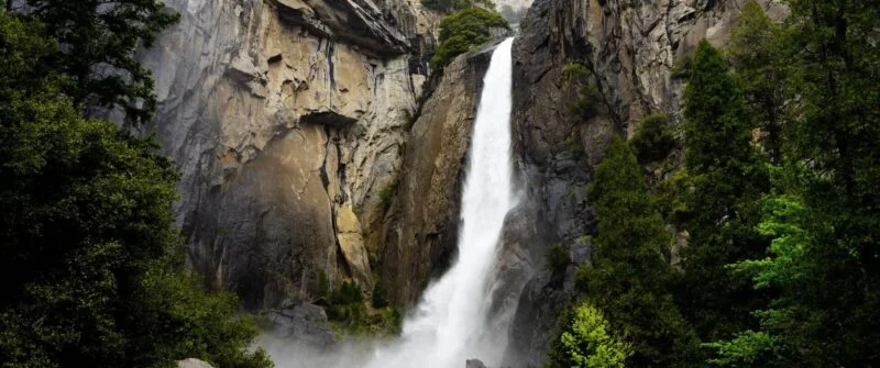 Majestic waterfall cascading down rocky cliffs, nature inspiration for NYC web design.